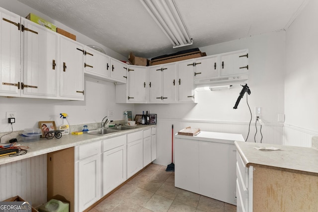 4701 Cleveland Hwy, Gainesville, GA 30506 - kitchen with a sink, wainscoting, white cabinets, and light countertops