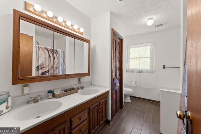 4701 Cleveland Hwy, Gainesville, GA 30506 - full bath with toilet, double vanity, wood finished floors, and a textured ceiling