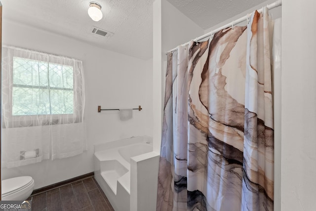 4701 Cleveland Hwy, Gainesville, GA 30506 - bathroom with a textured ceiling, a shower with curtain, toilet, wood finished floors, and a tub