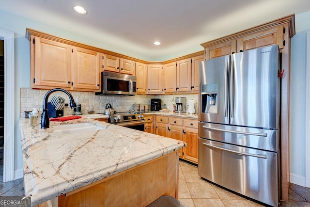 kitchen featuring a sink, stainless steel appliances, light brown cabinets, tasteful backsplash, and a peninsula