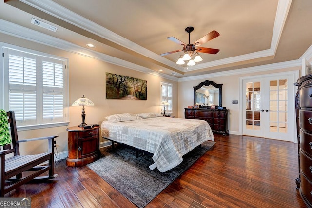bedroom featuring a raised ceiling, visible vents, dark wood-type flooring, and baseboards