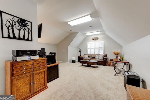 office area featuring lofted ceiling, visible vents, and light colored carpet