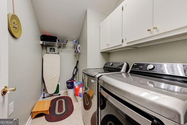 washroom with light tile patterned flooring, separate washer and dryer, cabinet space, and baseboards