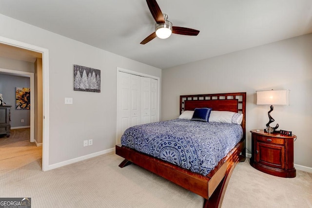 carpeted bedroom with ceiling fan, baseboards, and a closet
