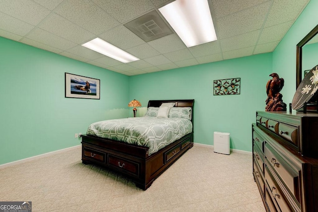 bedroom with visible vents, a drop ceiling, light carpet, and baseboards
