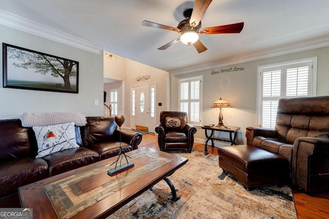 living area with wood finished floors, a ceiling fan, and crown molding