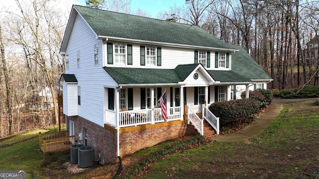 view of front facade featuring roof with shingles, a porch, and central AC unit