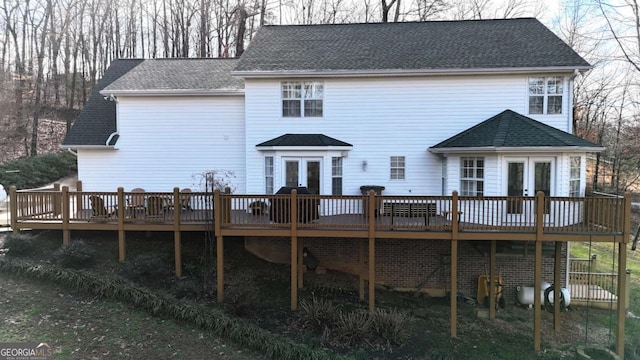 rear view of property featuring roof with shingles, a deck, and french doors