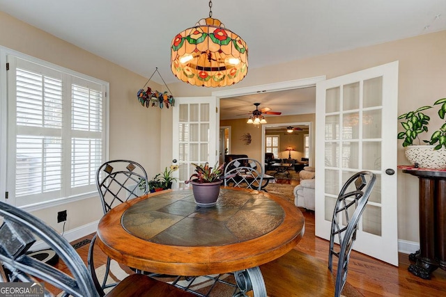 dining area featuring wood finished floors, ceiling fan, a wealth of natural light, and french doors
