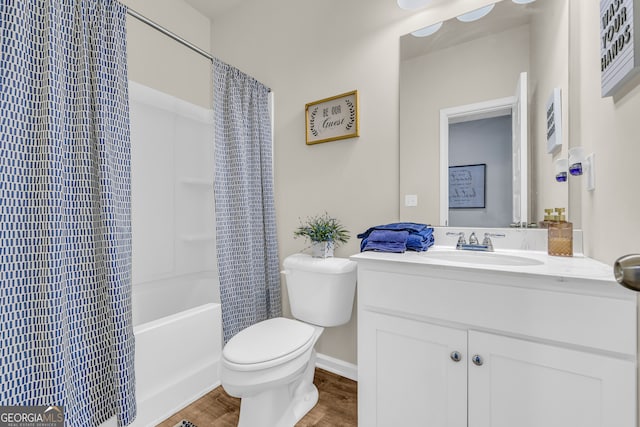 bathroom with vanity, toilet, shower / bath combination with curtain, baseboards, and wood finished floors