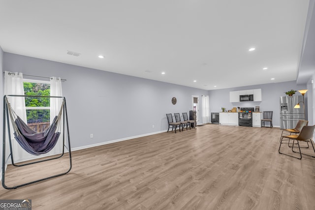 interior space featuring recessed lighting, baseboards, light wood finished floors, and visible vents