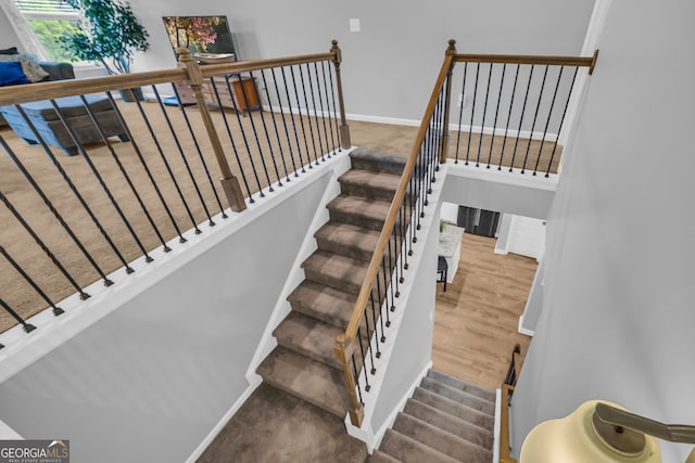staircase with baseboards and wood finished floors