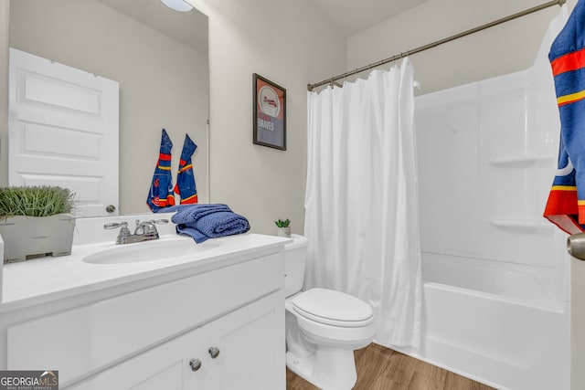 full bath with toilet, shower / bath combination with curtain, wood finished floors, and vanity
