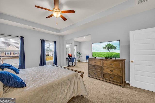 bedroom with baseboards, light carpet, a ceiling fan, and visible vents