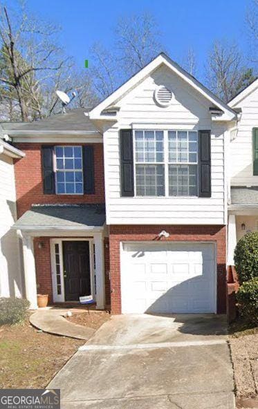 view of front of property with concrete driveway, brick siding, and a garage