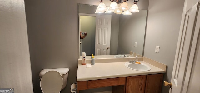 half bath with vanity, a notable chandelier, and toilet