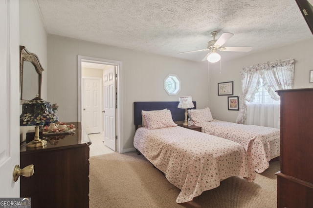 bedroom featuring a textured ceiling, light colored carpet, and ceiling fan