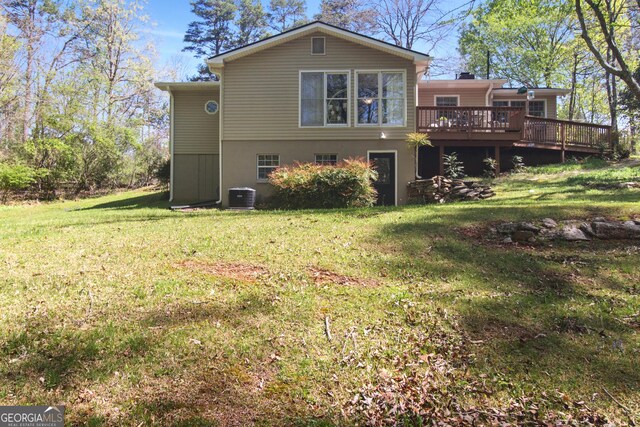 rear view of property featuring a wooden deck, a lawn, and central AC unit