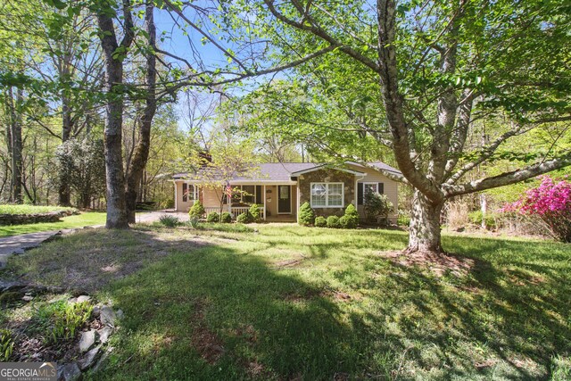 ranch-style house with a porch and a front lawn