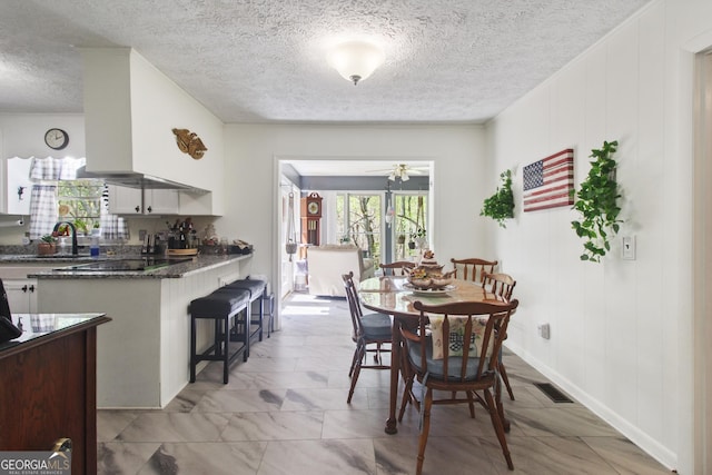 dining room with visible vents, a textured ceiling, and ceiling fan