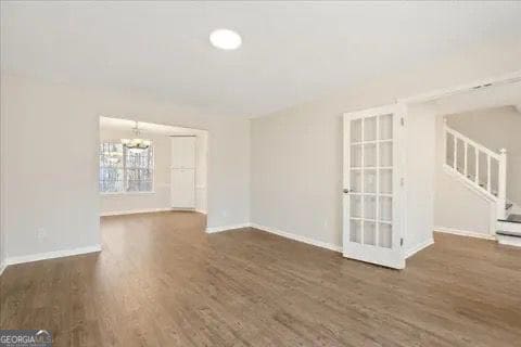2317 Rocksram Ct, Buford, GA 30519 - interior space featuring stairs, baseboards, a notable chandelier, and wood finished floors