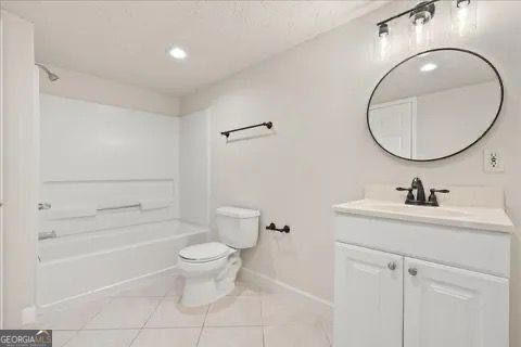 2317 Rocksram Ct, Buford, GA 30519 - full bathroom with vanity, tile patterned floors, baseboards, toilet, and tub / shower combination