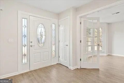 2317 Rocksram Ct, Buford, GA 30519 - foyer entrance with french doors, baseboards, and wood finished floors