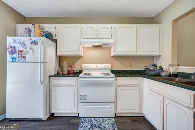 108 Magnolia Plantation Trce Unit 108, Hinesville, GA 31313 - kitchen with dark countertops, under cabinet range hood, white appliances, white cabinetry, and dark wood-style flooring
