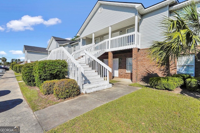 108 Magnolia Plantation Trce Unit 108, Hinesville, GA 31313 - exterior space featuring a porch, a lawn, and brick siding