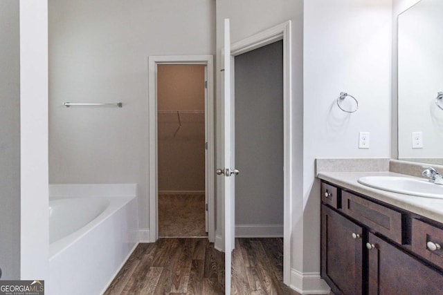 440 Dublin Way, Dallas, GA 30132 - full bathroom with a bath, wood finished floors, a spacious closet, and vanity