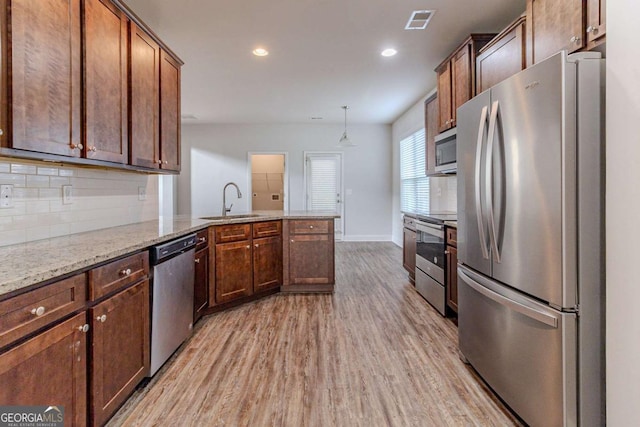 440 Dublin Way, Dallas, GA 30132 - kitchen with a sink, light wood-style floors, decorative backsplash, a peninsula, and appliances with stainless steel finishes