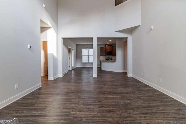 440 Dublin Way, Dallas, GA 30132 - unfurnished living room with a towering ceiling, baseboards, and dark wood-style flooring