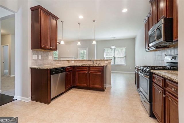 2212 Reddy Farm Ln, Grayson, GA 30017 - kitchen featuring a peninsula, light stone countertops, appliances with stainless steel finishes, and baseboards