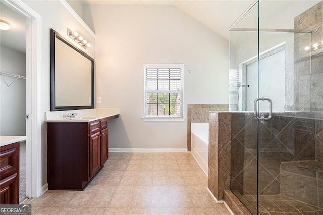 2212 Reddy Farm Ln, Grayson, GA 30017 - bathroom with a stall shower, vaulted ceiling, baseboards, a garden tub, and vanity