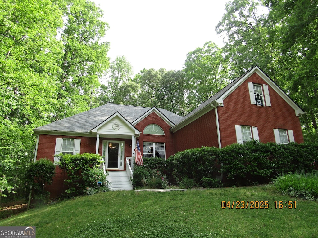view of front facade featuring a front lawn and brick siding