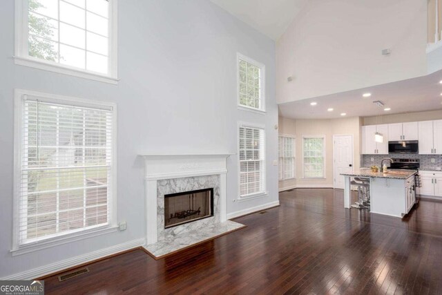 1533 Fallen Leaf Dr SW, Marietta, GA 30064 - unfurnished living room featuring visible vents, a towering ceiling, a high end fireplace, and a healthy amount of sunlight