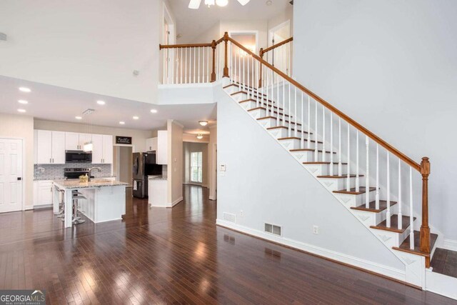 1533 Fallen Leaf Dr SW, Marietta, GA 30064 - unfurnished living room featuring stairway, dark wood-style floors, a high ceiling, and visible vents