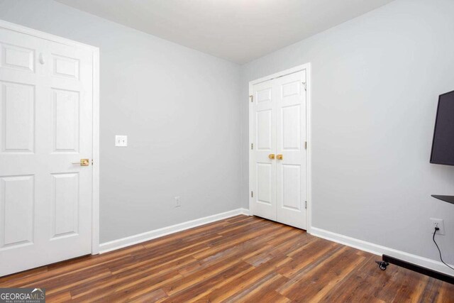 1533 Fallen Leaf Dr SW, Marietta, GA 30064 - unfurnished bedroom with baseboards and dark wood-style floors