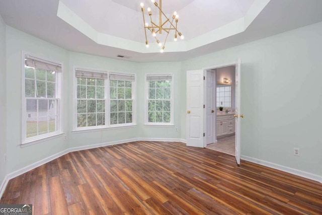 1533 Fallen Leaf Dr SW, Marietta, GA 30064 - empty room featuring a tray ceiling, visible vents, baseboards, an inviting chandelier, and wood finished floors