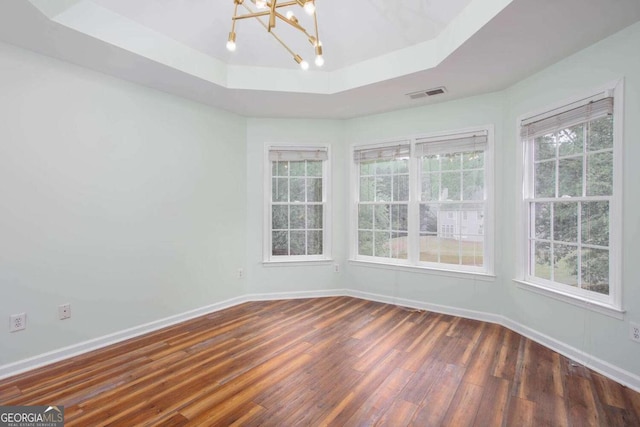 1533 Fallen Leaf Dr SW, Marietta, GA 30064 - spare room with an inviting chandelier, a raised ceiling, visible vents, dark wood-type flooring, and baseboards
