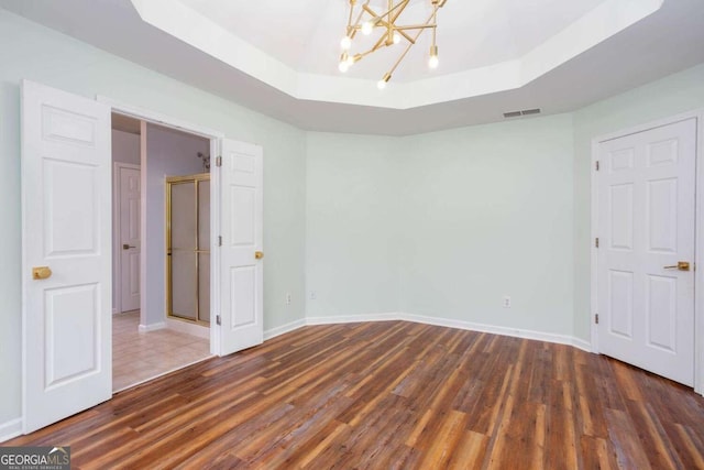 1533 Fallen Leaf Dr SW, Marietta, GA 30064 - unfurnished bedroom featuring a tray ceiling, visible vents, baseboards, an inviting chandelier, and wood finished floors