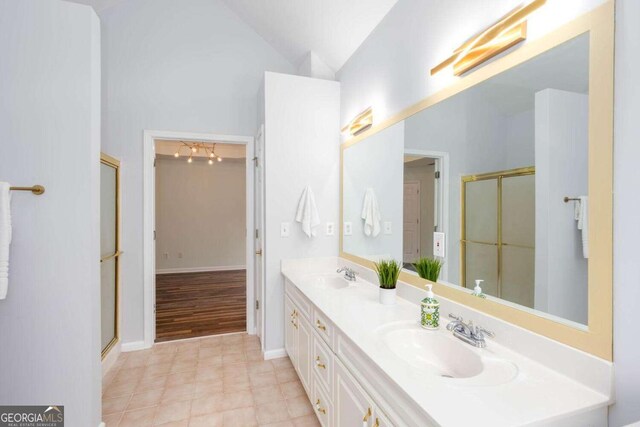 1533 Fallen Leaf Dr SW, Marietta, GA 30064 - bathroom featuring double vanity, vaulted ceiling, a sink, and a shower with door