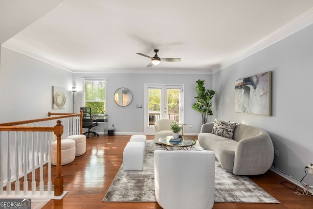 living area featuring hardwood / wood-style floors, a ceiling fan, ornamental molding, and baseboards