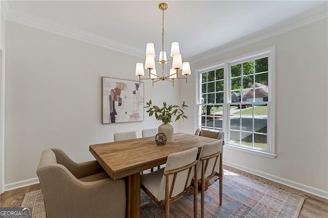 dining room with wood finished floors, baseboards, a chandelier, and ornamental molding