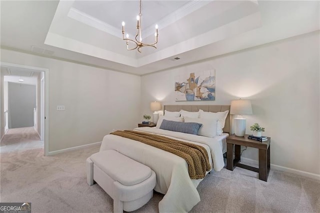 bedroom with attic access, an inviting chandelier, carpet, and a raised ceiling