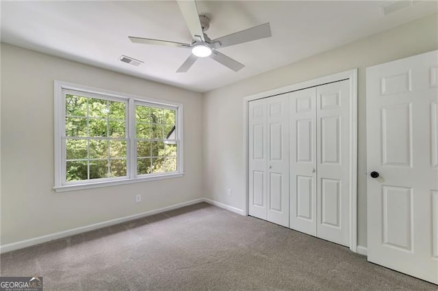 unfurnished bedroom featuring visible vents, a ceiling fan, carpet floors, a closet, and baseboards