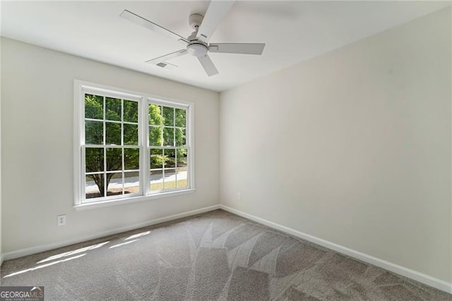 spare room with carpet, baseboards, and ceiling fan