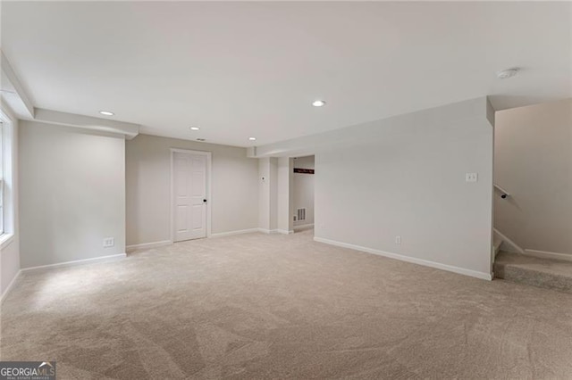 spare room with stairway, baseboards, recessed lighting, and light colored carpet