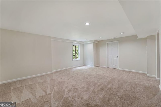 empty room featuring recessed lighting, light carpet, and baseboards