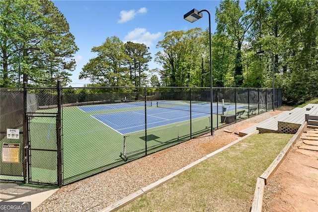 view of tennis court featuring a gate and fence